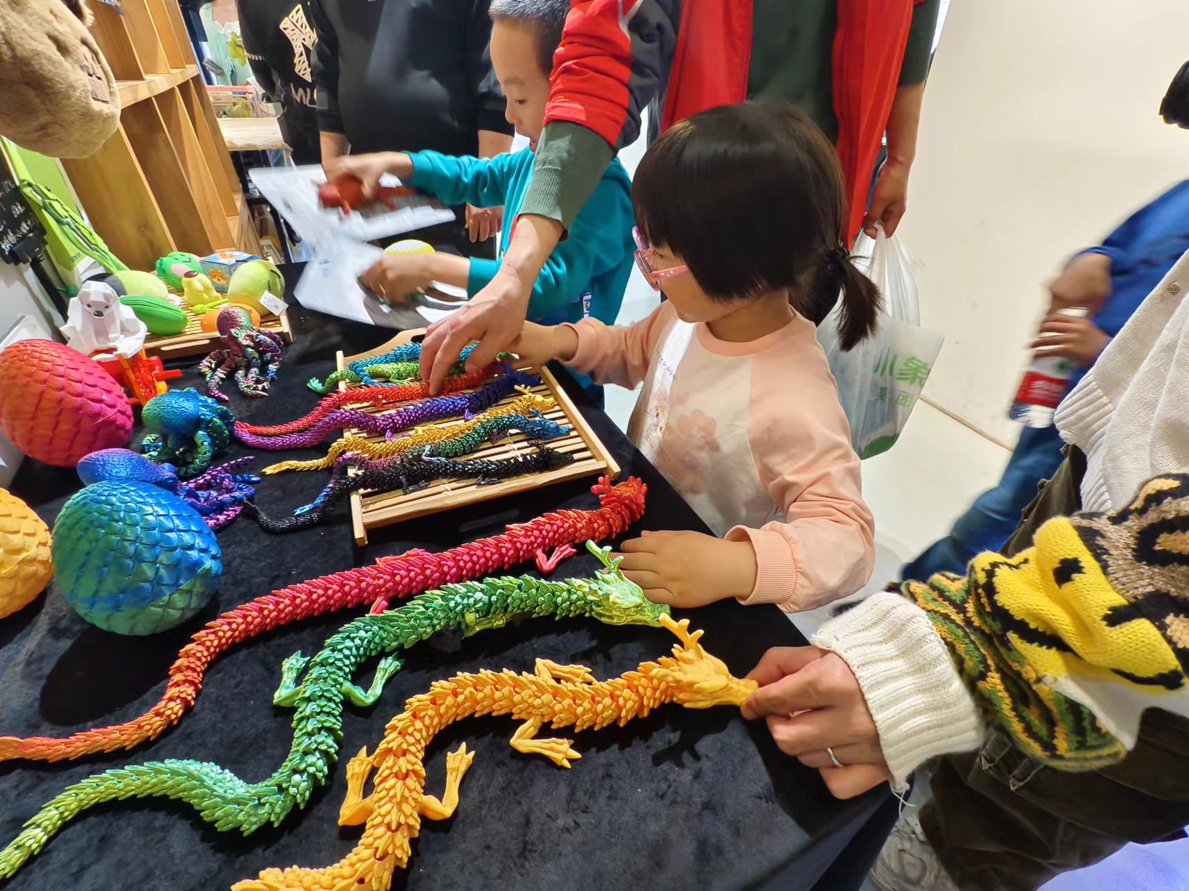在北京798某创意产品店内，孩子们正在选购3D打印的龙形玩具。人民网记者 乔业琼摄